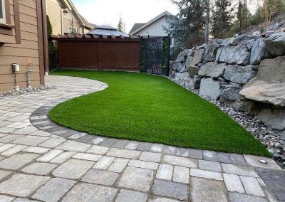 Kalagan Outdoor Design turf next to stone retaining wall